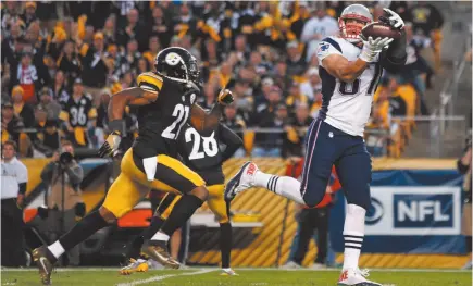  ?? AP PHOTO/JARED WICKERHAM, FILE ?? In this Oct. 23, 2016, file photo, New England Patriots tight end Rob Gronkowski (87) takes a pass from quarterbac­k Tom Brady behind Pittsburgh Steelers strong safety Robert Golden (21) for a touchdown during the second half of an NFL football game in...