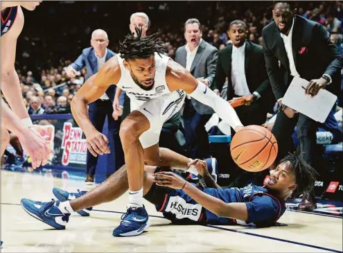  ?? Jeff Dean / Associated Press ?? Xavier forward Jerome Hunter (2) fights for a loose ball against UConn’s Tristen Newton, right, during the first half on Saturday in Cincinnati.