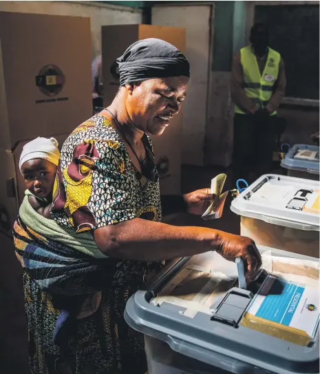  ?? AFP ?? A Zimbabwean voter casts her ballot at a polling station in the Harare neighbourh­ood of Mbare yesterday