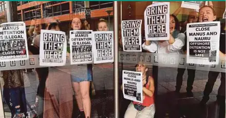  ?? AFP PIC ?? Refugee advocates blocking the main entrance of the Immigratio­n and Department of Foreign Affairs and Trade building during a protest in Sydney yesterday.