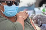  ?? DRAKE PRESTO/THE REPUBLIC ?? LEFT: Brenda Hankins receives her COVID-19 vaccine from pharmacist Tesfu Telinte on March 13 at Cortez Park.