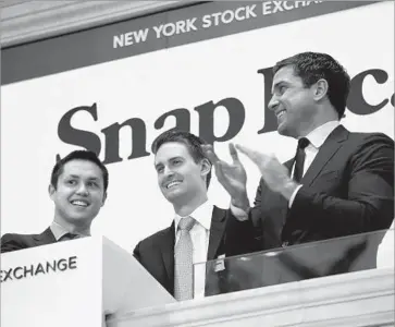  ?? Carolyn Cole Los Angeles Times ?? CO-FOUNDER Evan Spiegel, center, at Snap’s market debut. He has said that it will take five years for his company to reach its full potential and that investors should focus on how existing users interact with the app.