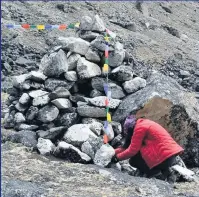  ??  ?? EMOTIONAL Sarah buries her mum’s ashes at fiance Gerry’s memorial cairn in the Himalayas. Below, with her sherpa on top of the mountain