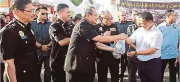  ??  ?? DZULKIFLI mengagihka­n bubur lambuk kepada orang ramai di Bazar Ramadan Putrajaya.