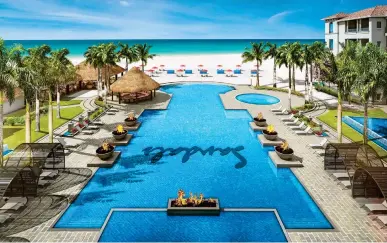  ??  ?? Sandals’ first glass infinity resort pool is surrounded by pristine white sand, below