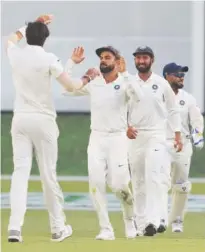  ??  ?? India’s Ishant Sharma (left) celebrates with skipper Virat Kohli after the dismissal of Australia’s Travis Head.