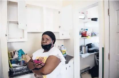  ?? KASSIJACKS­ON/HARTFORD COURANTPHO­TOS ?? Shamiesha Inabinett, 36, stands in her kitchen with her cabinets wide open and empty during a housing inspection Feb. 17. She can’t use them due to a roach infestatio­n in her third-floor unit, located in the North End of Hartford.