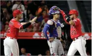  ?? AP PHOTO BY CHRIS CARLSON ?? Los Angeles Angels' Jose Fernandez, right, celebrates after his two-run home run with Andrelton Simmons, left, as Texas Rangers catcher Robinson Chirinos look000s away during the third inning of a baseball game in Anaheim, Calif., Wednesday.