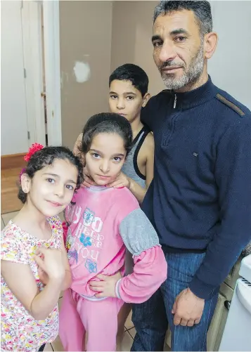  ?? RIC ERNST ?? Amjad Ktifan poses with his children Ritaj, 8, Saja, 10, and Maan, 11, left to right, at their two-bedroom basement apartment in Delta. Ktifan and his wife, Wadaa, also have twin infants.