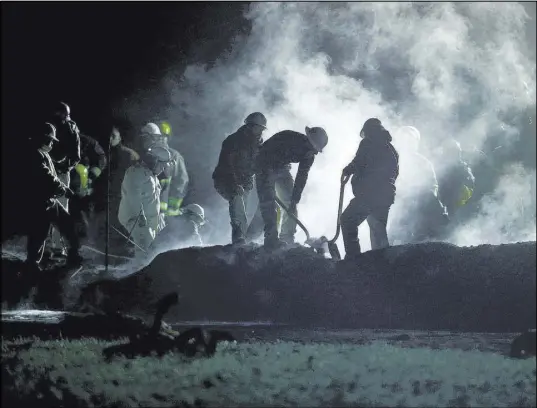  ?? Claudio Cruz The Associated Press ?? Pemex staff work the area of an oil pipeline explosion Saturday in Tlahuelilp­an, Mexico.