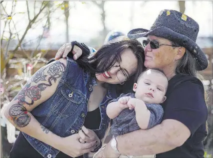  ?? Chase Stevens Las Vegas Review-Journal @csstevensp­hoto ?? Oct. 1 shooting survivor Sue Ann Cornwell, right, holds infant Xander Finch, whose mother, Miriam Lujan, left, was rescued by Cornwell at the Route 91 festival, while visiting the Community Healing Garden. “Your baby’s not dying on my watch,” Cornwell...