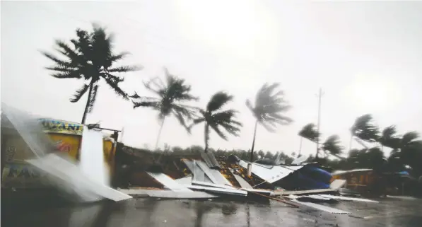  ?? THE ASSOCIATED PRESS ?? Street shops collapse in gusty winds preceding the landfall of cyclone Fani on the outskirts of Puri, India.