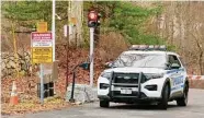  ?? Christian Abraham/Hearst Connecticu­t Media ?? New York City Environmen­tal Protection Police block off an entrance to woods in the area around 113 King St. in Armonk, N.Y., Friday. Two people were killed in a plane crash in the area the night before, according to officials.