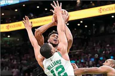  ?? STEVEN SENNE / AP ?? The Bucks’ Giannis Antetokoun­mpo, center top, is defended by the Celtics’ Grant Williams (12) defends during the first half of Game 7 in their Eastern Conference semifinals playoff series on Sunday in Boston.