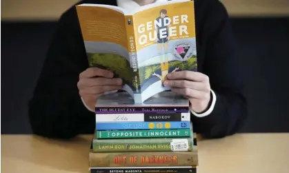  ?? Salt Lake City. Photograph: Rick Bowmer/AP ?? Amanda Darrow of the Utah Pride Center, poses with books that have been the subject of complaints from parents, in December 2021 in