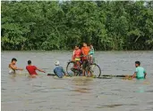  ?? — PTI ?? Villagers on a raft made of banana trees move to a safer place from the flooded area of Baksa district’s Goalbil, Assam, on Thursday.