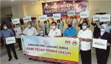  ?? PIC BY DANIAL SAAD ?? Penang Chief Minister Chow Kon Yeow and state officials holding a banner to promote Covid19 vaccinatio­n at the Penang Hospital Vaccine Delivery Centre yesterday.