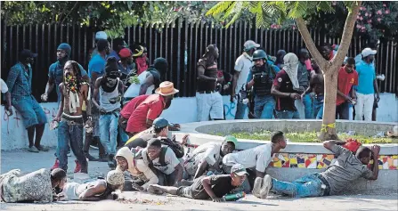  ?? DIEU NALIO CHERY THE ASSOCIATED PRESS ?? Protesters take cover during a demonstrat­ion demanding the resignatio­n of Haitian President Jovenel Moise in Port-au-Prince, Haiti, Wednesday.