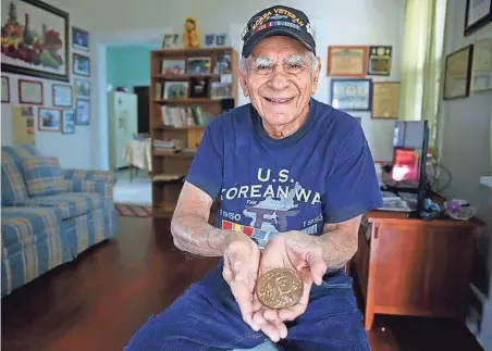  ?? MIKE DE SISTI / MILWAUKEE JOURNAL SENTINEL ?? Korean War veteran Cesar Pabon Peres holds his Congressio­nal Gold Medal he received last year for serving in the 65th Infantry Regiment from Puerto Rico. Pabon Peres is returning to South Korea with 15 other Puerto Rican Korean War veterans. See more...