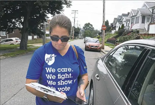  ?? Darrell Sapp/Post-Gazette ?? Christy Baraff of the Pittsburgh Federation of Teachers looks at her notes Wednesday in Brookline as she visits nonmembers to convince them to pay dues. In June, U.S. Supreme Court ruled labor unions cannot require public sector workers to pay membership dues.