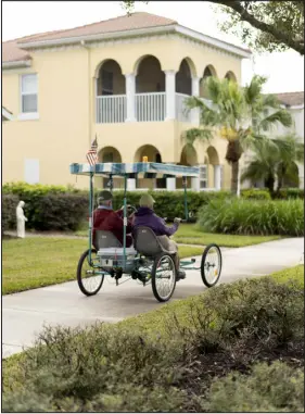 ?? ?? Two residents ride their quadricycl­e in Ave Maria, Fla.