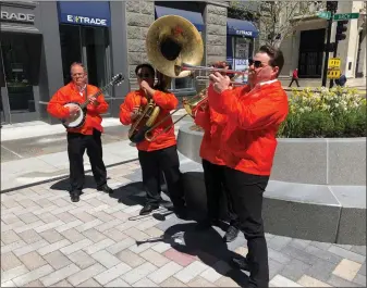  ?? AP ?? Dan Gabel, right, and fellow musicians perform in downtown Boston on May 10. Gabel has canceled Netflix and other streaming services and tried to cut back on driving as the costs of gas, food and other items, such as the lubricants he uses for his instrument­s, has soared. In the photo, from left to right, are Eric Baldwin, banjo; Ed Goroza, sousaphone; Josiah Reibstein, trombone; and Gabel, trumpet.