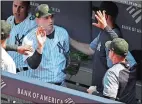  ?? KATHY WILLENS/AP PHOTO ?? New York Yankees manager Aaron Boone, far right, greets New York Yankees relief pitcher Adam Ottavino who pitched out of a bases-loaded jam during the sixth inning of Sunday’s game against the Tampa Bay Rays at Yankee Stadium in New York.