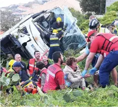  ??  ?? Firemen help victims of a tourist bus that crashed in Caniço, on the Portuguese island of Madeira.