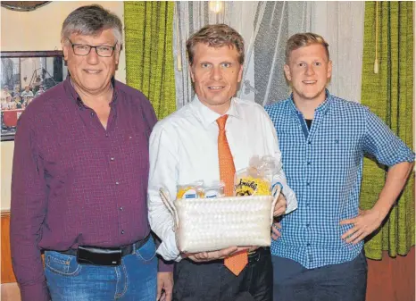  ?? FOTO: CHRISTOPH KLAWITTER ?? Thomas Bareiß (Mitte) erhält von Manfred Moll (links) und Eric Jäger (rechts) nach dem Diskussion­sabend ein Geschenk.