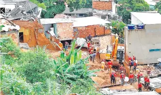  ??  ?? Bomberos buscan víctimas tras el colapso de algunas casas, en Vila Bernadete, Belo Horizonte. EFE