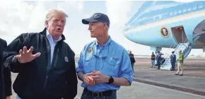  ?? EVAN VUCCI/AP ?? President Donald Trump talks with reporters alongside Gov. Rick Scott, right, after arriving at Eglin Air Force Base on Monday to visit areas affected by Hurricane Michael at the Panhandle military base.