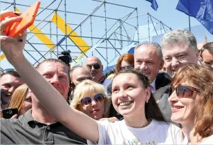  ??  ?? Ukrainian President Petro Poroshenko, right, poses for a selfie with people during a ceremony on the Slovak-Ukrainian border not far from Ukrainian city of Uzhgorod to mark the first day of visa-free travel to Europe on Sunday. (AFP)