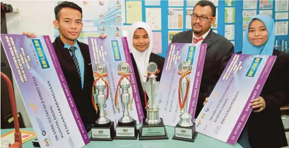  ?? [FOTO MOHD RAFI MAMAT/BH] ?? Guru, Mohd Fakharudin Mahmod (dua dari kanan), bersama Wan Aishah Wan Fatul (dua dari kiri) serta pelajar Sekolah Menengah Sains Sultan Haji Ahmad Shah (SEMSAS) meraih Anugerah Perdana Program Jalinan Sekolah Kluster Kecemerlan­gan (SKK) Universiti Awam...