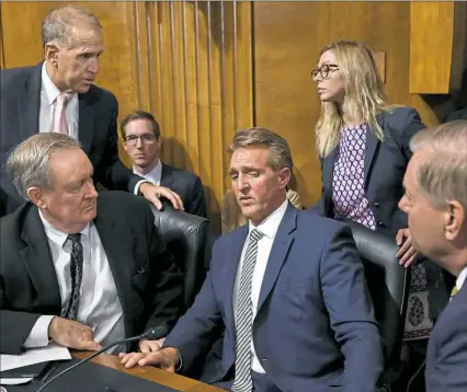  ?? Brendan Smialowski/AFP/Getty Images ?? Senate Judiciary Committee member Jeff Flake, R-Ariz., center, speaks with colleagues after a hearing Friday on Capitol Hill on the Supreme Court nomination of Judge Brett M. Kavanaugh.