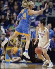  ?? JESSICA HILL — THE ASSOCIATED PRESS ?? UCLA’s Nicole Kornet, left, leaps in the air as she guards Connecticu­t’s Kia Nurse, right, during the first half of a regional semifinal game in the NCAA women’s college basketball tournament, Saturday in Bridgeport, Conn.