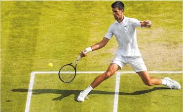  ?? AP PHOTO/WILL OLIVER ?? Novak Djokovic returns a shot against Roger Federer during the men’s singles final Sunday at Wimbledon.