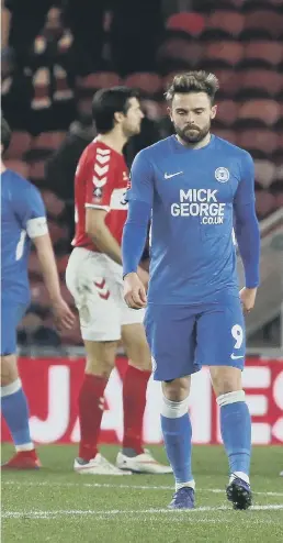  ??  ?? Posh substitute Matt Godden is forlorn as Boro players celebrate a goal.