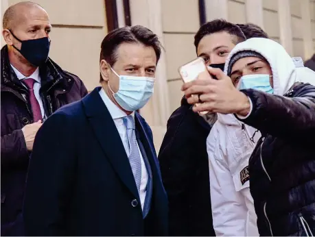  ??  ?? Selfie Il premier Giuseppe Conte, 56 anni, ieri in via Del Corso a Roma mentre posa con alcuni ragazzi che gli chiedono una foto (Imagoecono­mica)