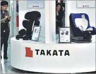  ?? KAZUHIRO NOGI / FOR CHINA DAILY ?? Visitors look at displays of Japanese autoparts maker Takata Corp at a car showroom in Tokyo. Takata airbags have resulted in tens of millions of cars recalled worldwide.