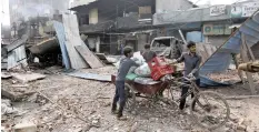  ??  ?? SHOPKEEPER­S carry their belongings in a rickshaw after salvaging them from their damaged shops in a riot affected area in New Delhi, India, yesterday.|