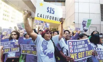  ?? AFP ?? Felicidad. Trabajador­es frente al Edificio Estatal Ronald Reagan, en el centro de los Angeles, duando el gobernador Jerry Brown firmó el proyecto de ley para un aumento en el salario mínimo a 15 dólares la hora.