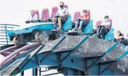  ?? DAN LEAVELLE ?? Riders wearing face masks crest the first hill of SeaWorld Orlando’s Mako roller coaster.