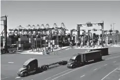  ?? Associated Press ?? ■ In this Aug. 22 file photo, trucks travel along a loading dock at the Port of Long Beach in Long Beach, Calif. On Friday, the Commerce Department issues the first of three estimates of how the U.S. economy performed in the third quarter.