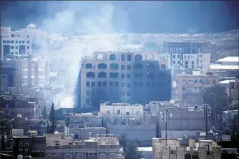  ?? Mohammed Huwais/ AFPGetty Images ?? Smoke billows behind a building in the Yemeni capital Sanaa on Sunday during clashes between Houthi rebels and supporters of Yemeni ex- President Ali Abdullah Saleh.