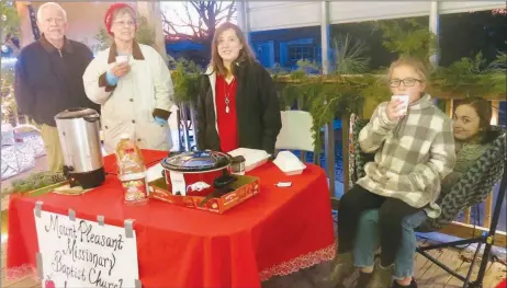  ?? Westside Eagle Observer/SUSAN HOLLAND ?? Dean and Wilma Fladager, of Bella Vista, pose with Carrie Dean, Zyla-Dell Dean and Cadence Dean, of Farmington, as they man the Mount Pleasant Missionary Baptist Church booth at the Hiwasse Hallmark Christmas event. The church, where Carrie’s husband Brian is pastor, provided hot cider and wassail at the event.