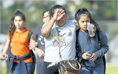  ?? DAMIAN DOVARGANES/ THE ASSOCIATED PRESS ?? People pick up students after a shooting at the Salvador B. Castro Middle School near downtown Los Angeles, Calif., on Thursday. A 15- year- old boy was shot in the head and a 15- year old girl was shot in the wrist.