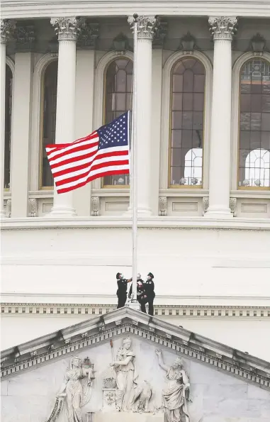  ?? JOE RAEDLE / GETTY IMAGES ?? The American flag is lowered to half-mast atop the U.S. Capitol Building in Washington Friday, following the death of a police officer who died of head injuries fighting off a pro-trump mob who stormed the Capitol on Wednesday.