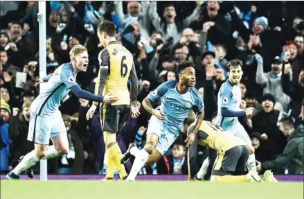  ?? OLI SCARFF/AFP ?? Manchester City midfielder Raheem Sterling (centre) celebrates scoring his team’s winner in the English Premier League match against Arsenal at the Etihad Stadium in Manchester, northwest England, on Sunday night.