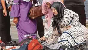  ??  ?? ISTERI mangsa nahas pesawat Indonesia mencari barang milik suaminya di pusat pengumpula­n di Pelabuhan Tanjung Priok, Jakarta, Indonesia.