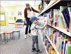  ?? Arnold Gold / Hearst Connecticu­t Media file photos ?? A mother and her son browse for books in the children’s section of the Guilford Library.